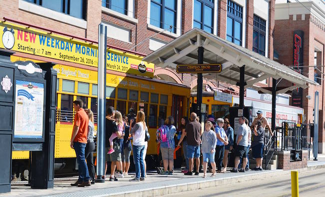 passengers wait to board a streetcar