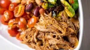 shredded pork, beans, tomatoes, veggies, and more in a bowl from Bolay