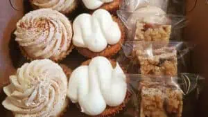 a box of iced cupcakes and gluten-free treats from Prattycakes