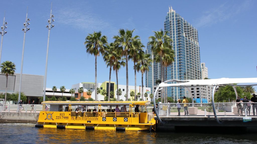 Bright yellow Pirate Water Taxi vessel docks outside Curtis Hixon Park in Tampa.