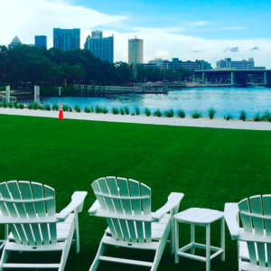 Photo shows lawn chairs on park grass looking out towards the Tampa skyline