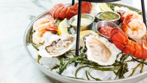 Photo of raw oysters and lobster tails over ice