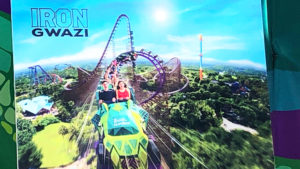 A rendering of Iron Gwazi showing riders coming out a fast loop near the top of the future rollercoaster