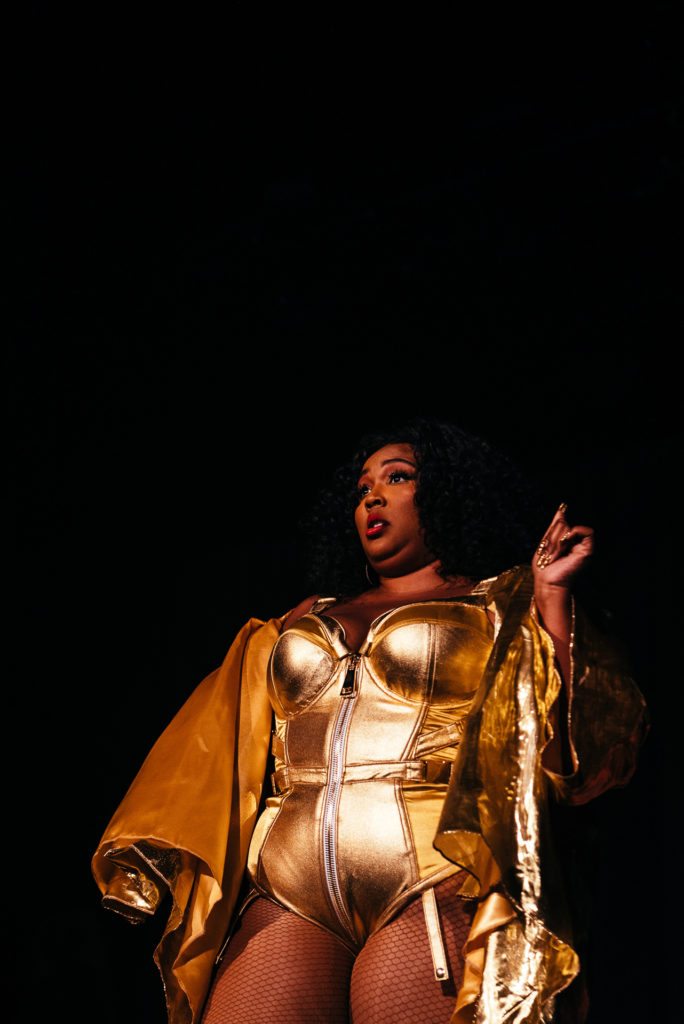 Lizzo posing while on stage performing