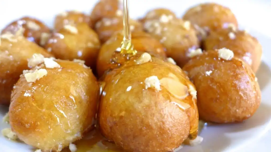 a plate of Greek donuts covered in honey