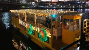 A yellow water taxi covered in Christmas Lights