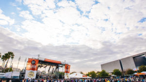 A cloud filled blue sky over the Gasparilla Music Festival stage and crowd
