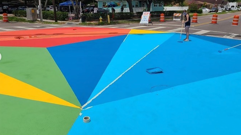 Photo of a street mural with geometric blue, green, and yellow patterns