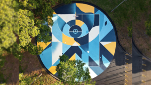 Aerial view of a blue and yellow mural on a basketball court