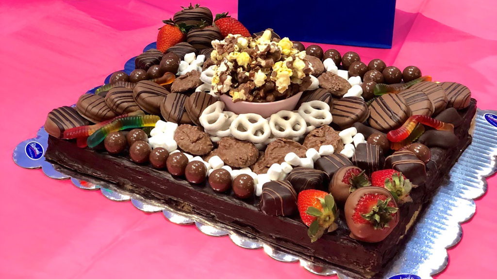 assorted chocolates, Oreos and pretzels arranged on a chocolate board