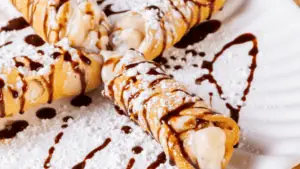 cannoli covered in chocolate on a white plate