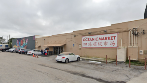 Exterior of a supermarket with "Oceanic" written in red on the front
