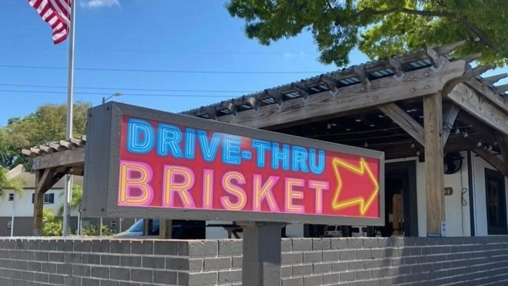 a drive thru sign outside a brick building