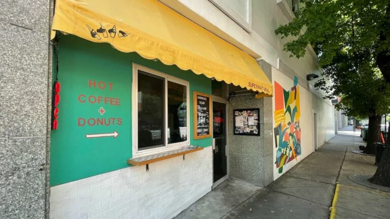 Exterior of a small sandwich and donut counter with a colorful mural