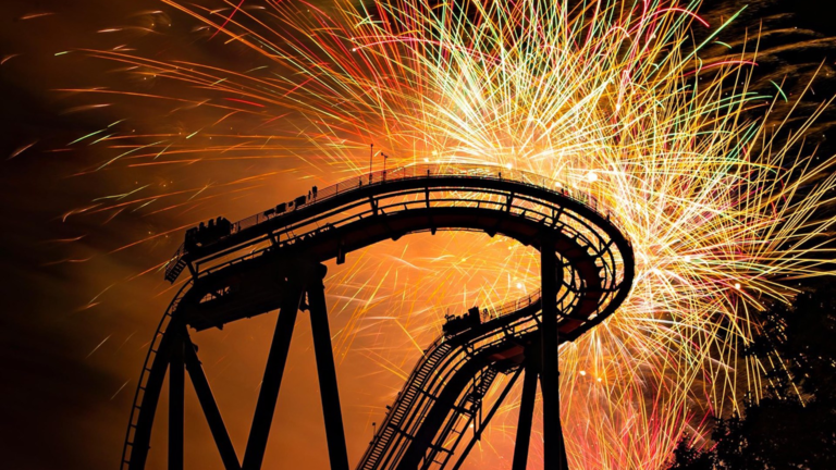 Fireworks display over a roller coaster