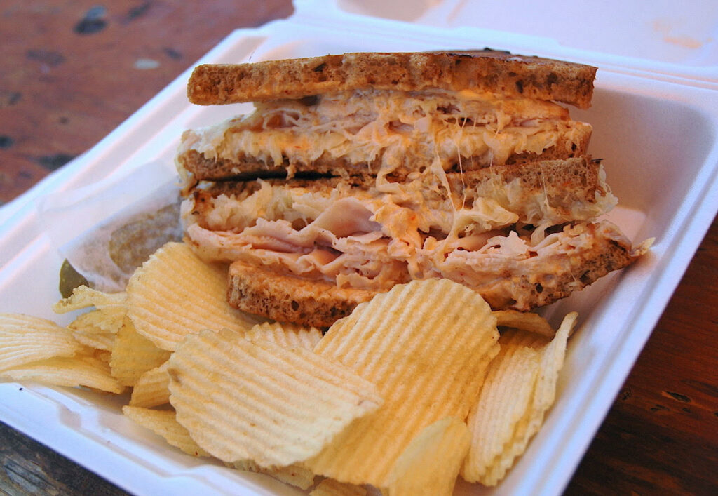 a giant pressed sandwich with potato chips