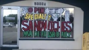 exterior of a small deli with a mural on the window