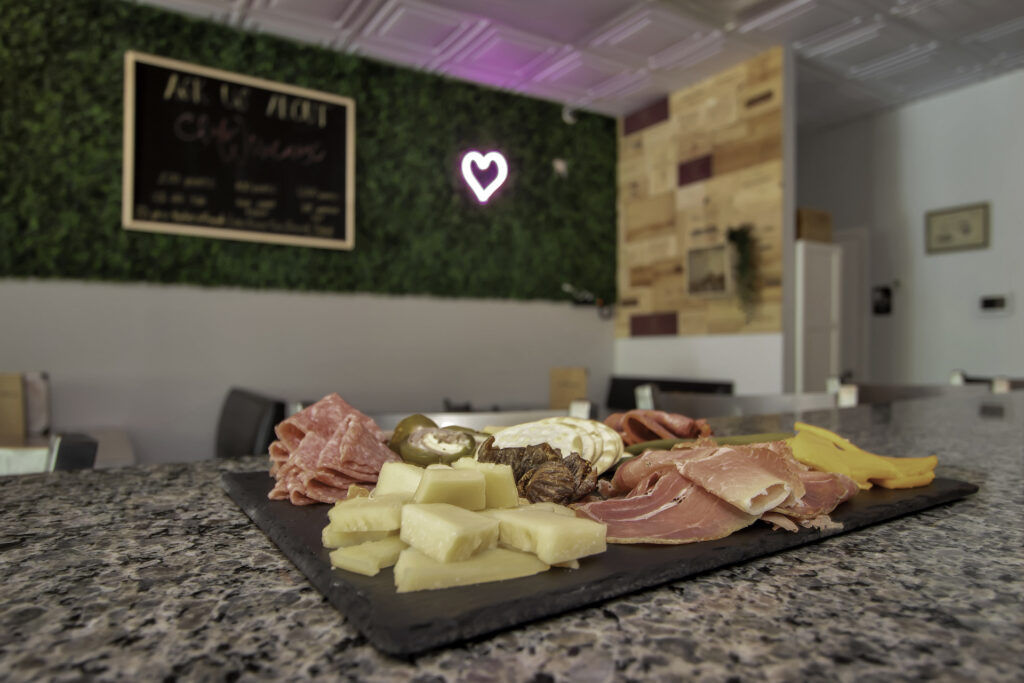 Plate of meats and cheeses on a granite countertop. 