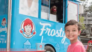 blue ice cream cart wit ha big Wendy's logo on the side