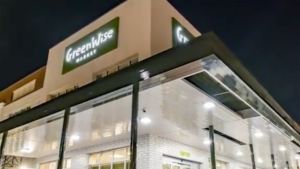 exterior of a grocery store at night with a green "Greenwise" sign