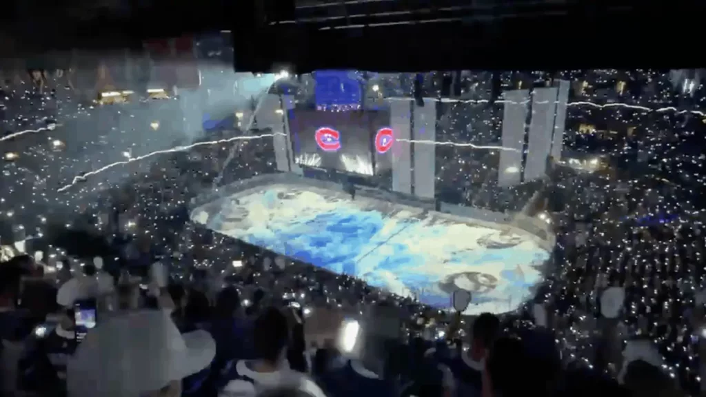 inside a hockey rink with blue and white lights flashing on the ice