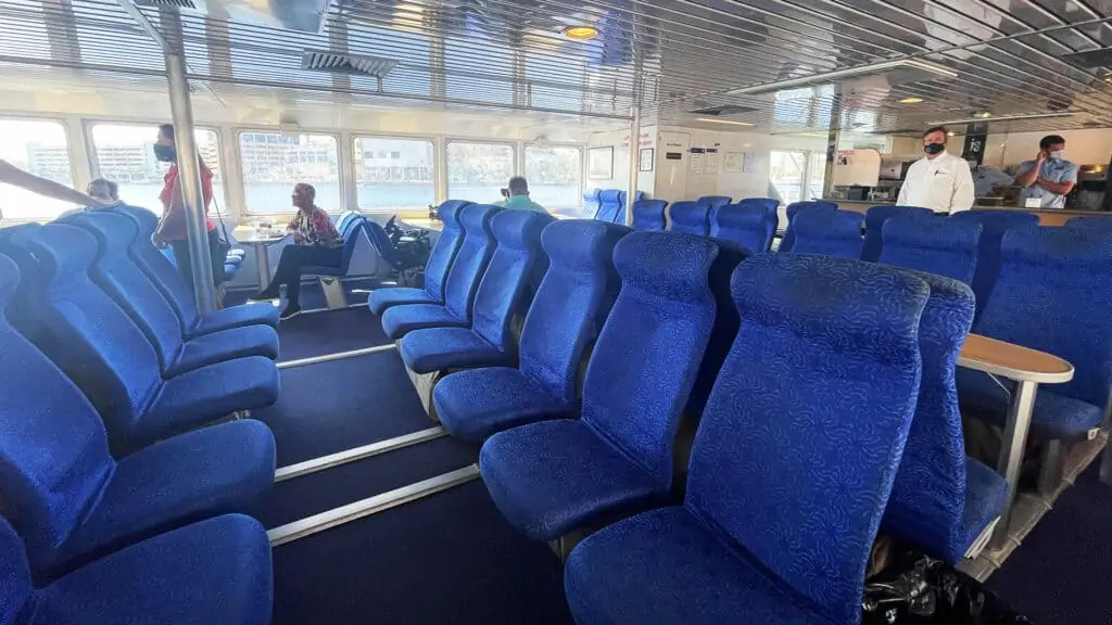 inside a ferry vessel with blue suits, and spanning windows