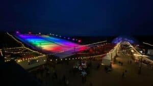 exterior of a snow park with a sledding hill covered in rainbow lights