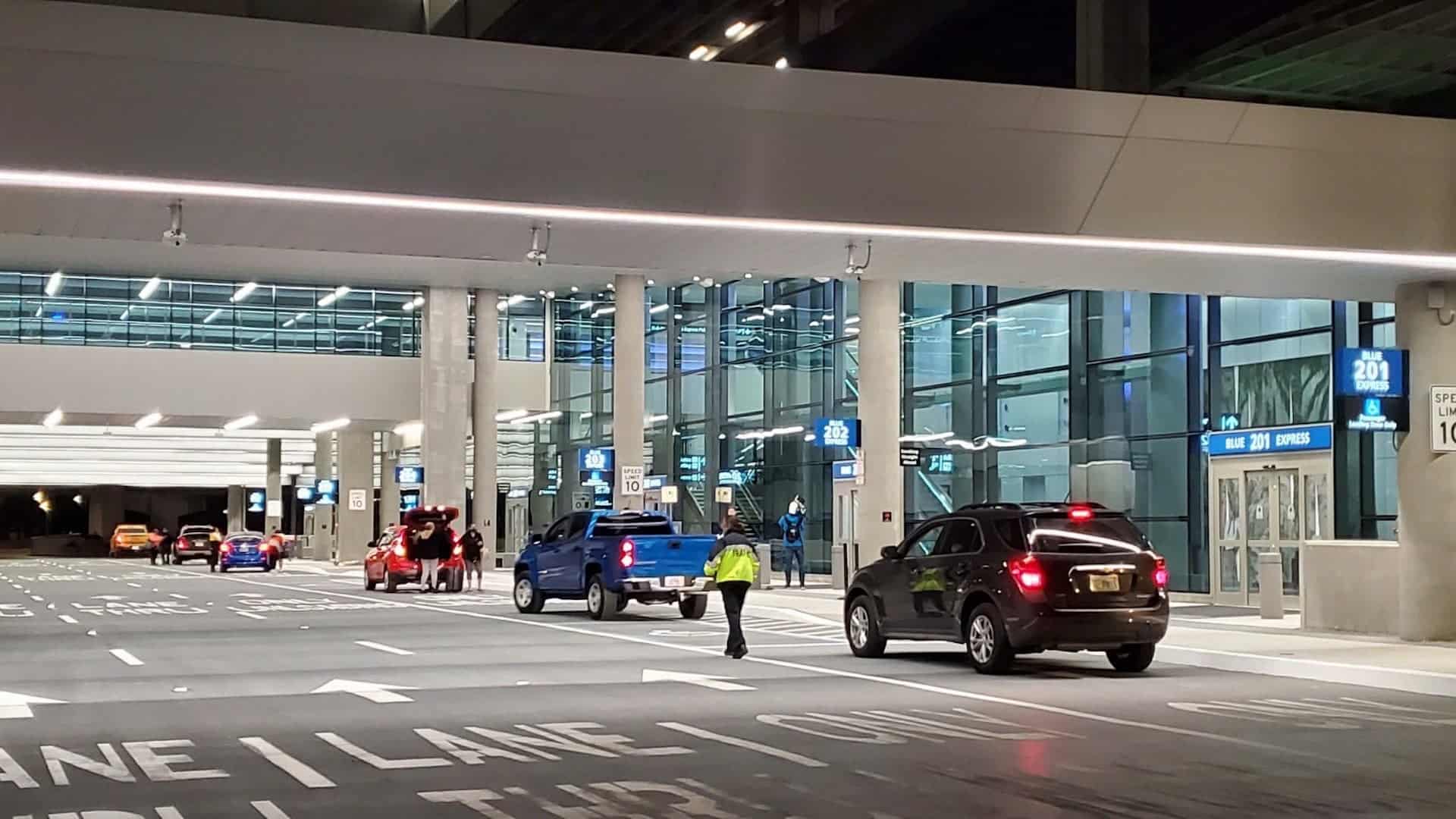 outside an airport with a line of cars riding through an express lane at sunrise