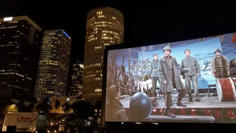 a large inflatable screen with a film projected on it in front of a skyline at night
