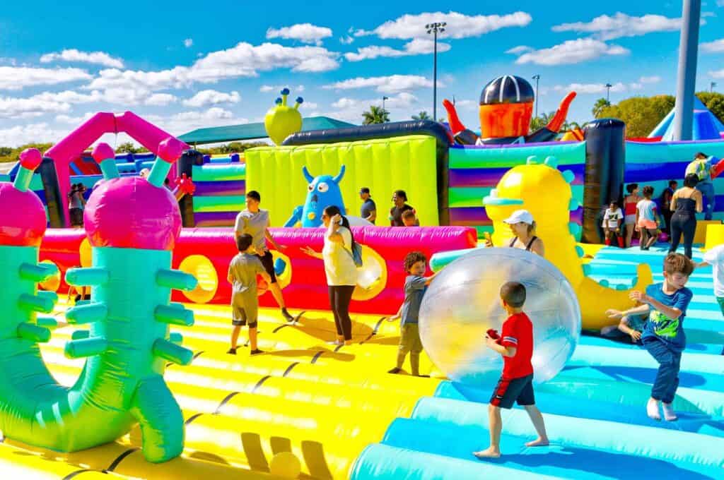 inside a massive colorful bounce house filled with inflatable characters and balls