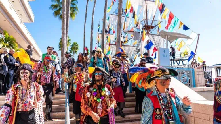 a group of pirates walking down steps in front of a pirate ship