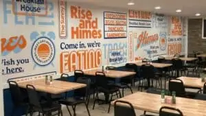 interior of a breakfast restaurant with orange writing on the walls