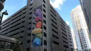 large parking garage with colorful stone mural on the side