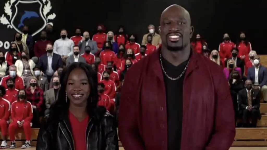 Two people standing side by side inside of a gym