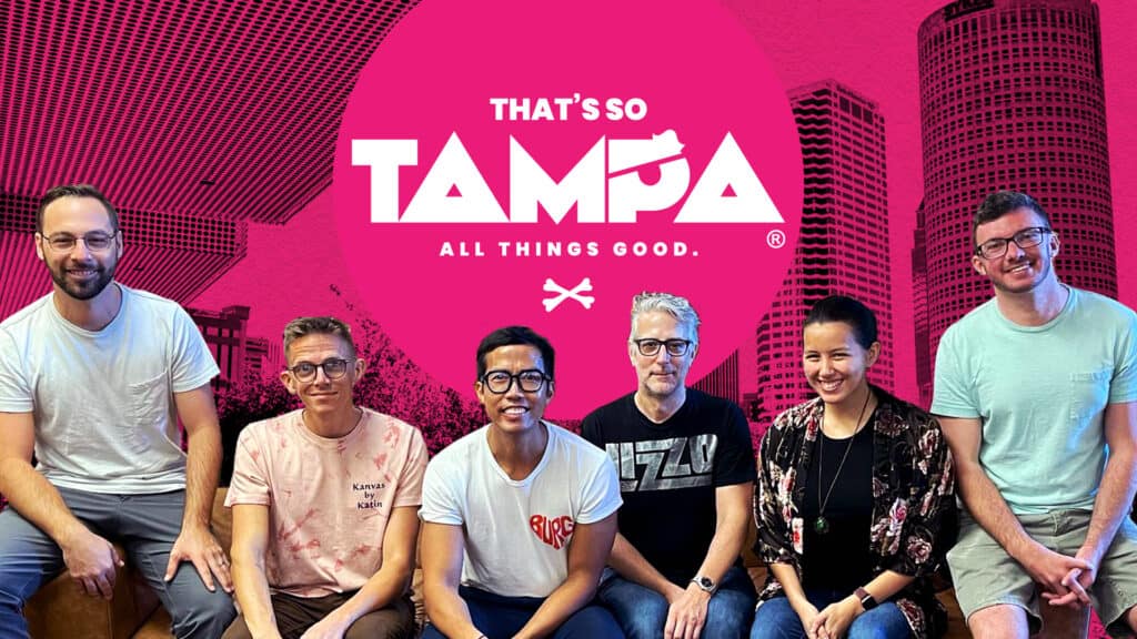 The That's So Tampa team seated, the new logo behind them