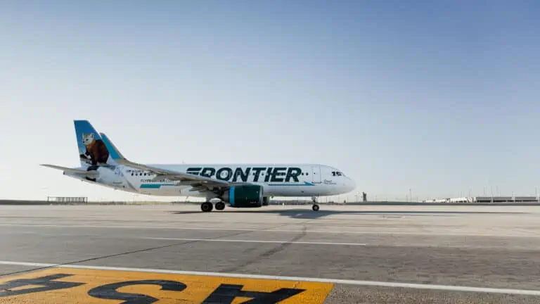 Exterior of an airplane on a runway with Frontier written on the side of the carrier