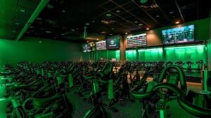 A spin studio with multiple bikes and green lighting