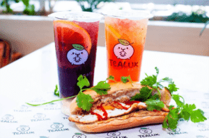 Two glasses of iced tea and a banh mi sandwich