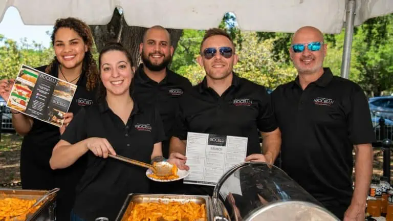 5 people in black shirts holding a tray of food