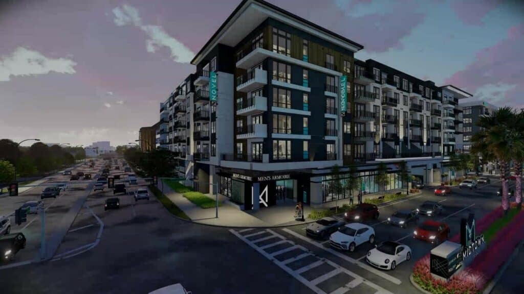 Rendering of a large condo tower at night. Traffic wraps around the building. 