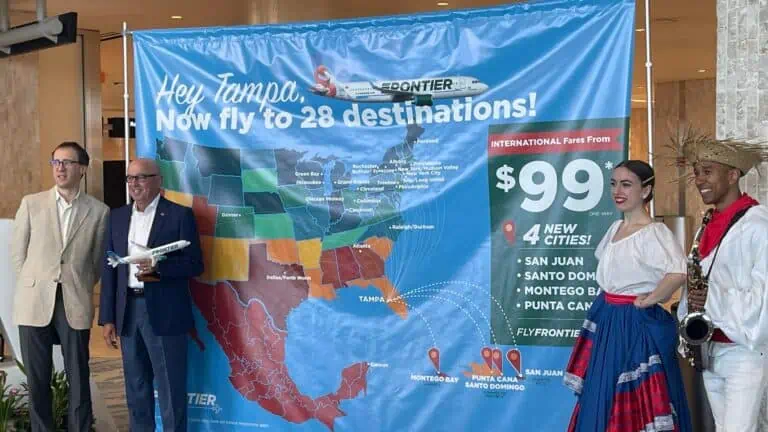 4 people standing in front of a large map showcasing different plane routes