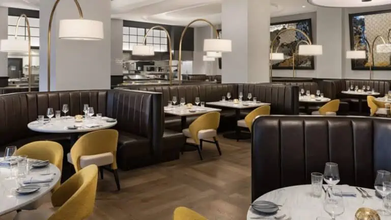 inside a luxury restaurant with brown leather booth and lamps hanging from golden rods