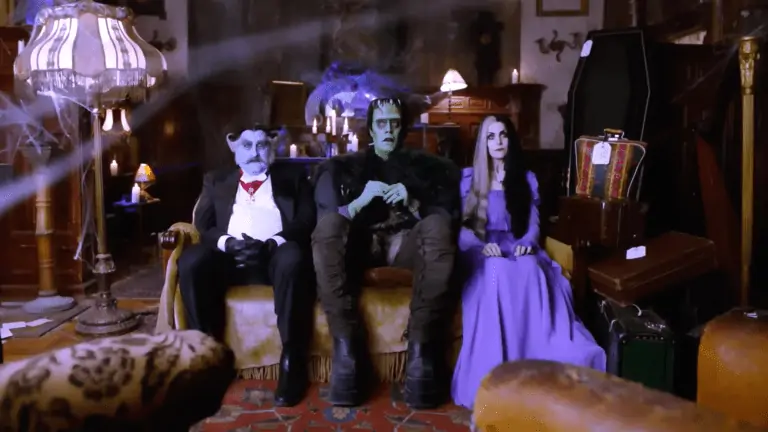Photo of three actors on a couch in costumers/ One a vampire, another Frankenstein's monster, and the other is the bride of Frankenstein