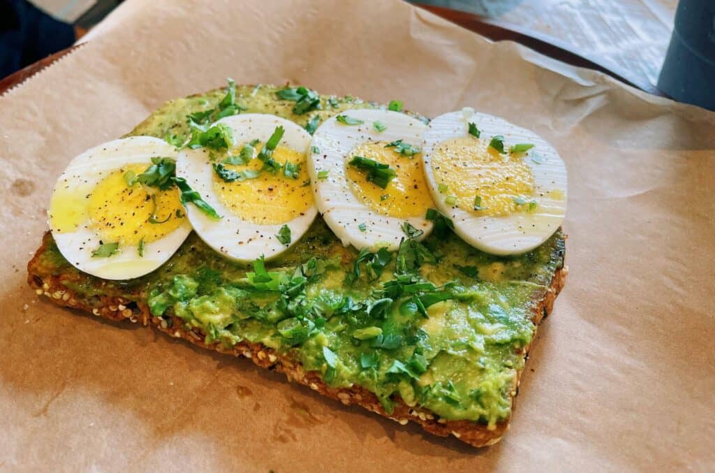 a piece of toast with avocado spread on top and sliced egg on top. 