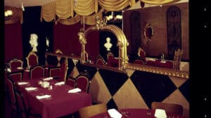inside a restaurant with black and white booths, and red carpets