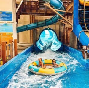 a child goes down a water slide in a yellow and blue tube