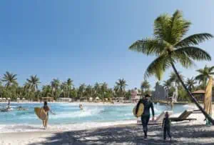 rendering of a surf park. a large crystal blue pool is surrounded by eager surfers. Palm trees are visible.