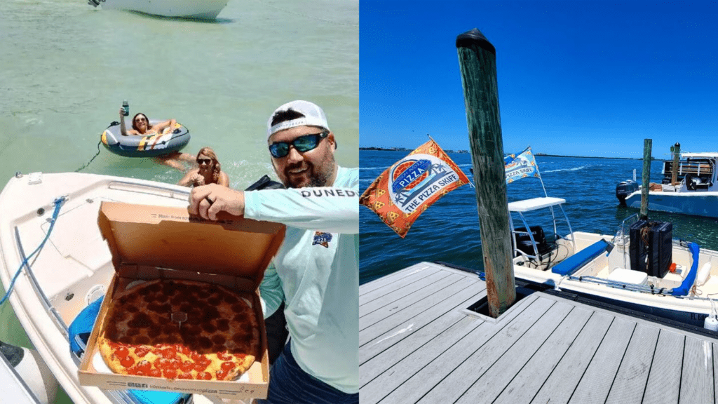 A man holds a box of pizza aboard a boat. A boat with a pizza flag hitched to the back docks