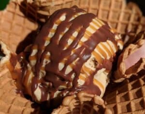 a big waffle bowl with vanilla ice cream covered in chocolate drizzle