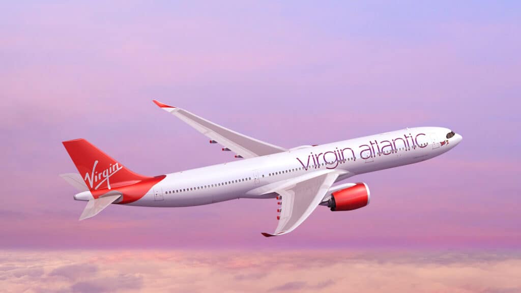 A plane lifts off above the clouds. The scenery has a pink hue, and the plane itself has a red tail fin
